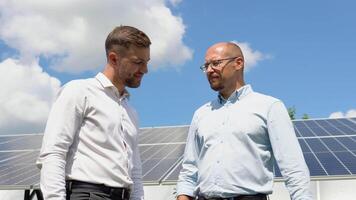 twee arbeiders controleren de geïnstalleerd zonne- panelen. groen elektriciteit concept video