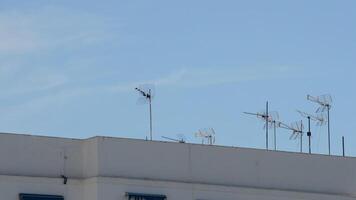 Antennas receiving television signal on the roof of a building a sunny day video