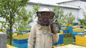 une apiculteur avec vieux abeille fumeur sur le rucher. apiculture concept video