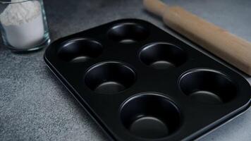 voorbereidingen treffen een muffin pan voor bakken in een huis keuken gedurende de dag video