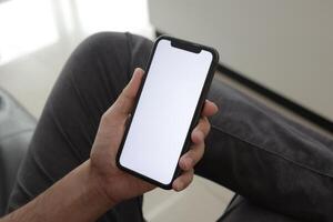 Hand holding smartphone in office, using phone photo