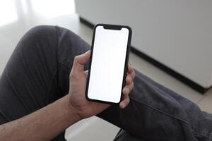 Hand holding smartphone in office, using phone photo