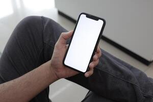 Hand holding smartphone in office, using phone photo