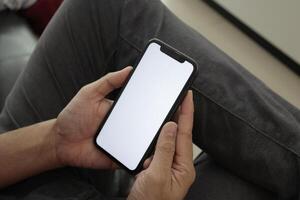 Hand holding smartphone in office, using phone photo