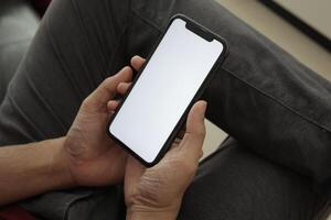 Hand holding smartphone in office, using phone photo