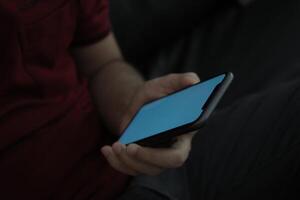 Hand holding smartphone in office, using phone photo