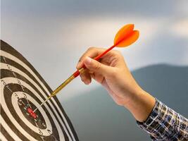 A dart hitting the bullseye of a dartboard symbolizes achievement and precision in business or sports. Aim the target precisely. photo