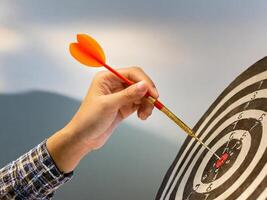A dart hitting the bullseye of a dartboard symbolizes achievement and precision in business or sports. Aim the target precisely. photo
