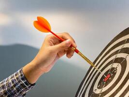 A dart hitting the bullseye of a dartboard symbolizes achievement and precision in business or sports. Aim the target precisely. photo