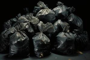 A pile of black plastic garbage bags stacked on top of each other on a concrete floor. photo