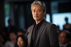 A man stands confidently in front of a microphone, preparing to speak to an audience. photo