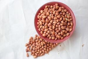 Peanuts are usually made into sauces or peanut butter, close up and selective focus, isolated on white background. photo