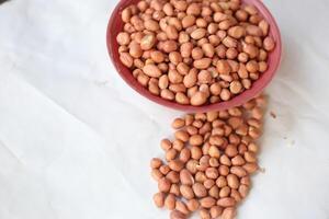 Peanuts are usually made into sauces or peanut butter, close up and selective focus, isolated on white background. photo