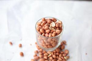 Peanuts are usually made into sauces or peanut butter, close up and selective focus, isolated on white background. photo