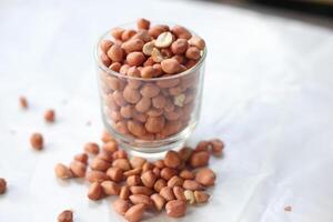 Peanuts are usually made into sauces or peanut butter, close up and selective focus, isolated on white background. photo