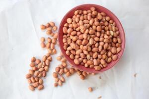 Peanuts are usually made into sauces or peanut butter, close up and selective focus, isolated on white background. photo