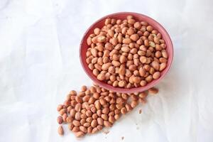 Peanuts are usually made into sauces or peanut butter, close up and selective focus, isolated on white background. photo