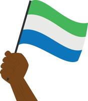 Hand holding and raising the national flag of Sierra Leone vector