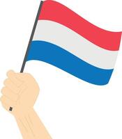 Hand holding and raising the national flag of Netherlands vector