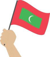 Hand holding and raising the national flag of Maldives vector