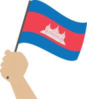 Hand holding and raising the national flag of Cambodia vector