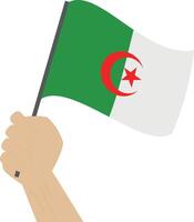 Hand holding and raising the national flag of Algeria vector