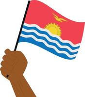 Hand holding and raising the national flag of Kiribati vector