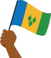 Hand holding and raising the national flag of Saint Vincent and the Grenadines vector