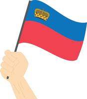 Hand holding and raising the national flag of Liechtenstein vector