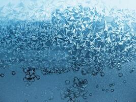 Ice pattern on winter window glass, natural blue background photo