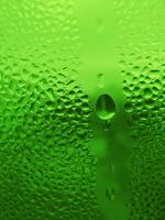 Water drops on glass, natural green background photo