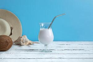 Coconut milk cocktail, a coconut and a summer hat photo