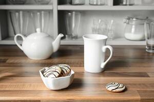 White tea cup, teapot and cookies photo