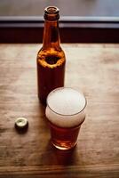 Opened beer bottle, bottle cap and glass with beer photo