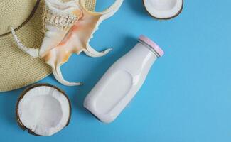 A bottle of vegan coconut milk and an exotic seashell photo