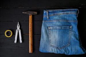 a pair of jeans, a hammer, and a pair of scissors photo