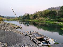 Beautiful view of an estuary with traditional boat for mining sand photo