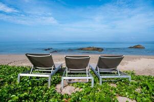 Beach chairs and beach morning glory on the beach at Lanta island, Krabi, Thailand photo