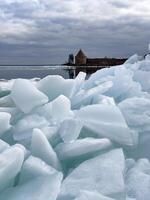 cristalino hielo hojas fractura y flotador en de rusia lago ladoga, capturar el rígido belleza de muelles deshielo debajo un nublado cielo. foto