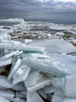 un dramático extensión de roto hielo hojas extensión a el horizonte debajo un temperamental nublado cielo, representando un rígido, frío ártico paisaje foto