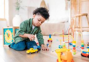 Concentrated latinos boy playing toys sitting on warm floor in modern living room. Baby development. Small tower. Learning creative concept photo