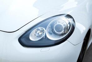 Kyiv, Ukraine - 11.04 2024. close up of headlight of luxury white Porsche. Headlight of the machine. photo