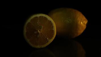 The cut and whole beautiful lemons lie on a dark background. HD video