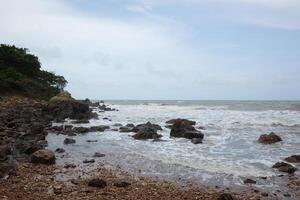 Beautiful landscape of Rocky coastline and blue sea with cloud storm on the sky in Thailand.Seascape concept photo