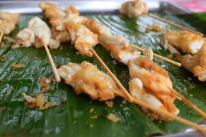 Squid eggs grilled on banana leaf. Seafood on street food in Thailand photo