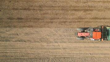 Top view of tractor sowing grain in the farm field. video