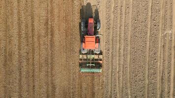 Top view of tractor sowing grain in the farm field. video