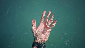 Slow Motion of Man immersing Hand into Azure River Water. Close up of male Hand with black Smartwatch on Wrist deepening in clean and transparent Water video