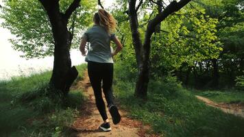 Two girls running on a forest path, running two young girls, rear view, morning running girls, running two athletes video