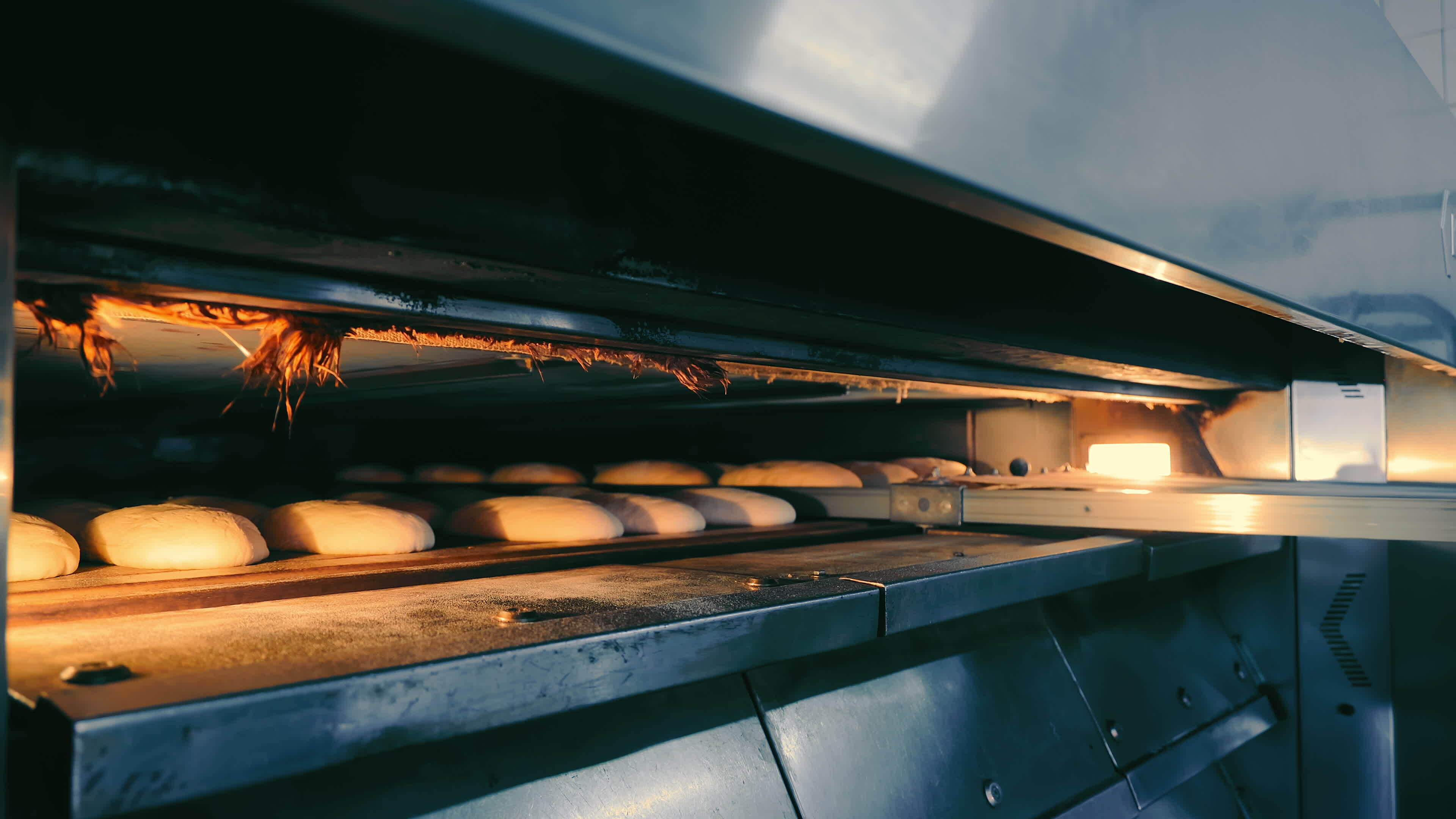 Bakery Worker putting Raw Loaves of Bread into Oven. Close Up of Male ...